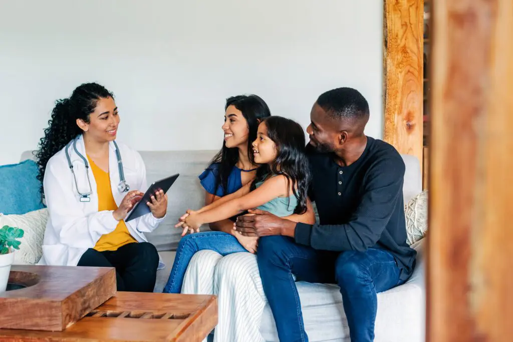 Doctor consulting with a smiling family group.